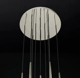 Chandelier canopy detail with a reflective silver circular ceiling plate and black suspension cords against a dark background.