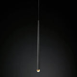 Chandelier detail showing a slender black tapered tube with an illuminated crystal tip against a dark gradient background.