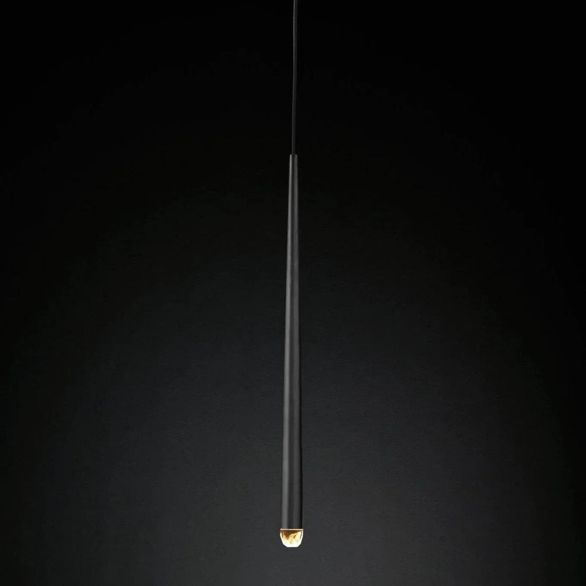 Chandelier detail showing a slender black tapered tube with an illuminated crystal tip against a dark gradient background.