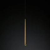 Chandelier detail showing a tapered brass tube with a clear crystal tip suspended against a dark background.