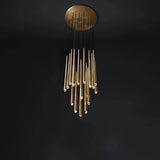 A modern chandelier with a circular gold ceiling mount and multiple hanging gold glass rods suspended by black cords, shown against a dark black background.