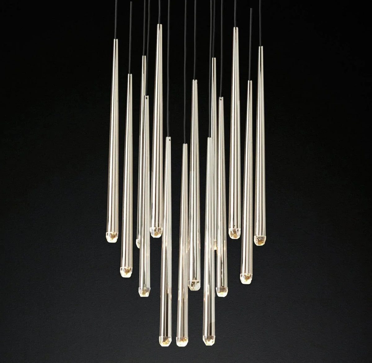 A modern chandelier featuring multiple clear glass teardrop-shaped pendant lights suspended from black cords against a solid black background.