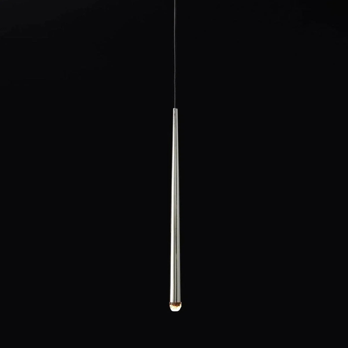 Chandelier detail showing a reflective silver tapered tube with a glowing crystal tip suspended against a black background.