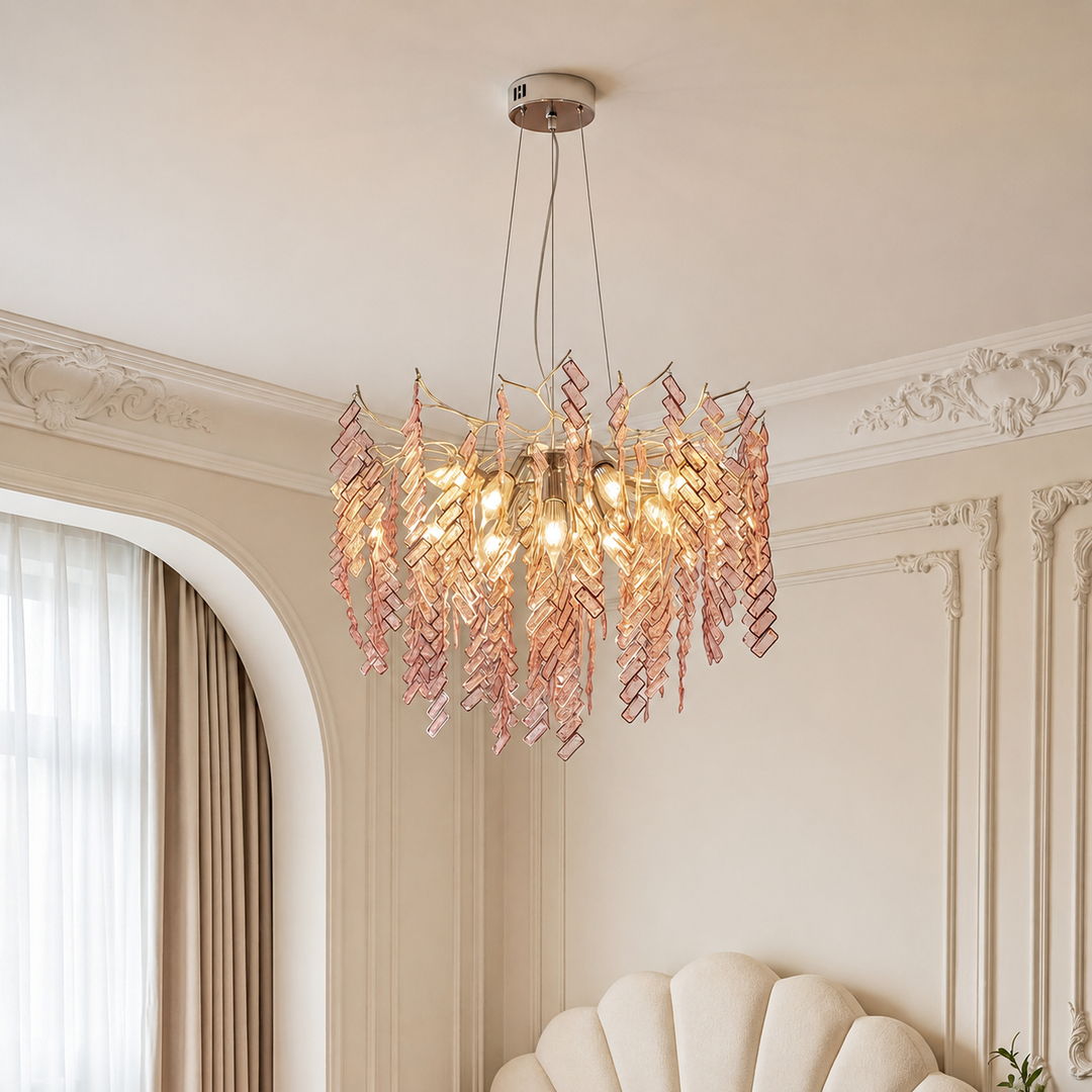 Chandelier with pink and gold leaves in a room with decorative walls and a window.