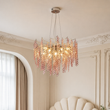 Chandelier with pink and gold leaves in a room with decorative walls and a window.