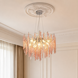 Chandelier with pink and gold accents hanging from a decorative ceiling fixture.