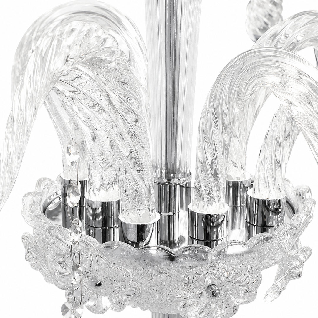 Close-up of a clear glass chandelier with sculptural curved glass arms and polished silver metal accents on a white background.