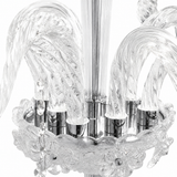 Close-up of a clear glass chandelier with sculptural curved glass arms and polished silver metal accents on a white background.