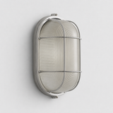 An oval wall sconce with a silver cage frame and ribbed frosted glass is mounted vertically on a light gray wall.