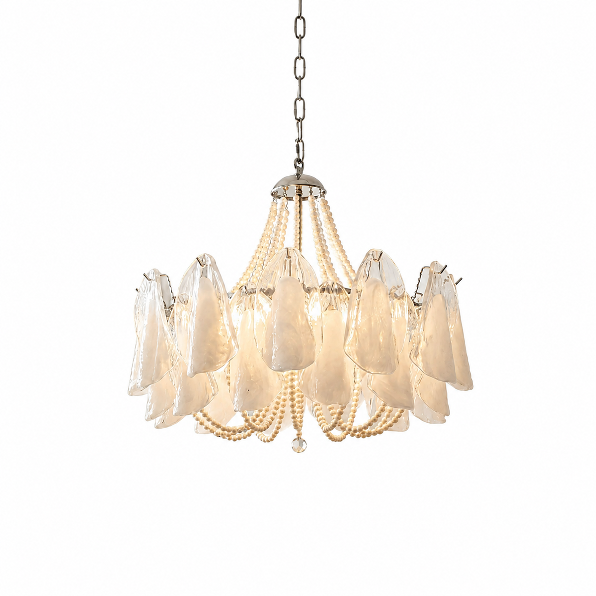 Chandelier with translucent petal-shaped glass shades and cream beaded strands hanging from a silver chain, lit warmly against a white background.