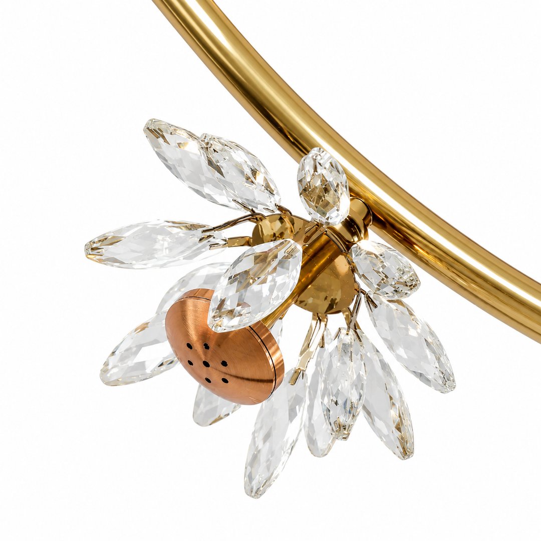 Close-up of the gold linear chandelier showing faceted clear crystal petals surrounding a gold light fitting against a white background.