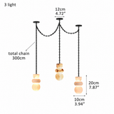 A 3-light chandelier pendant lamp with black metal chains and warm beige stone shades, shown with dimension labels on a white background.