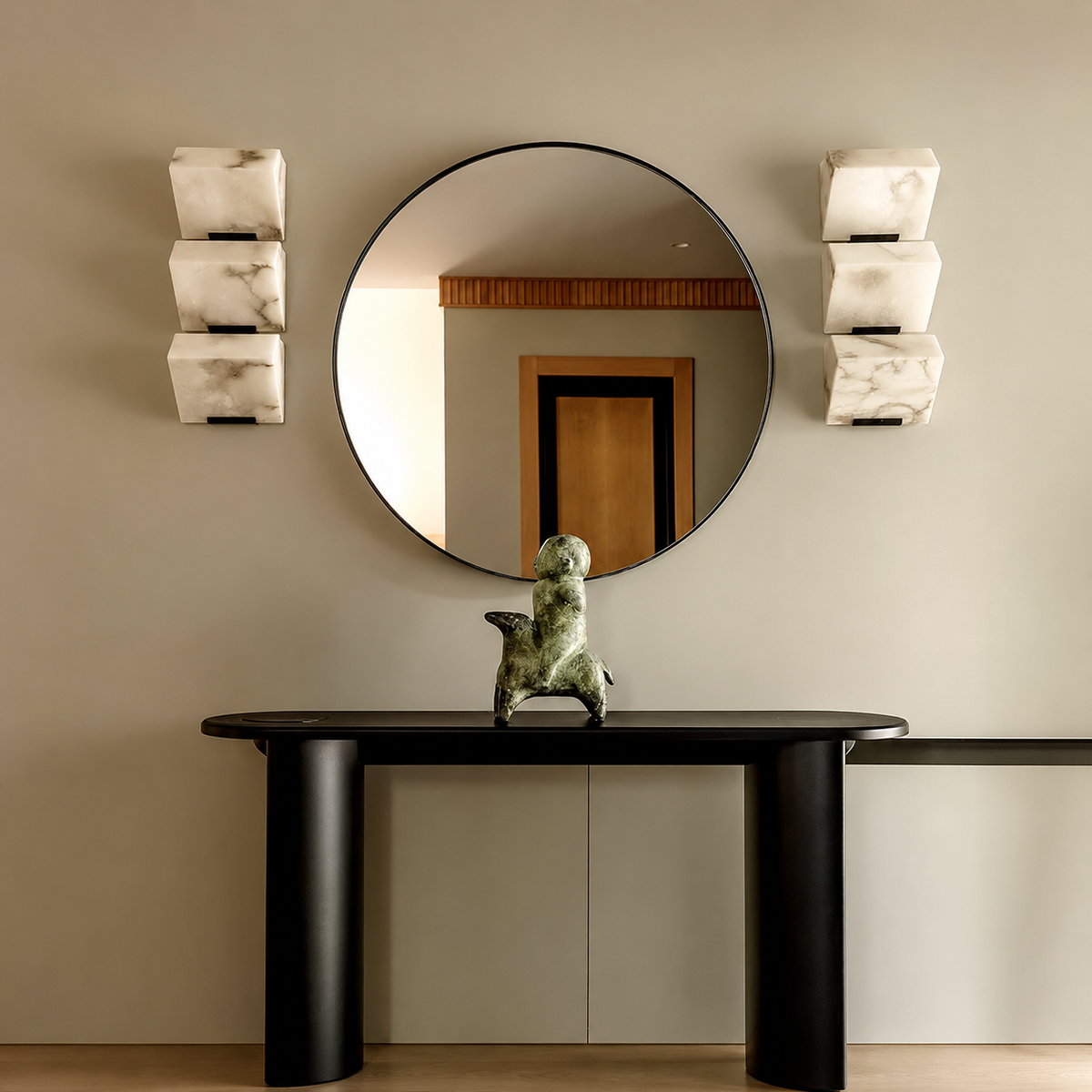 Matching three-light alabaster wall sconce fixtures with black frames flank a round mirror above a black console on a beige wall.