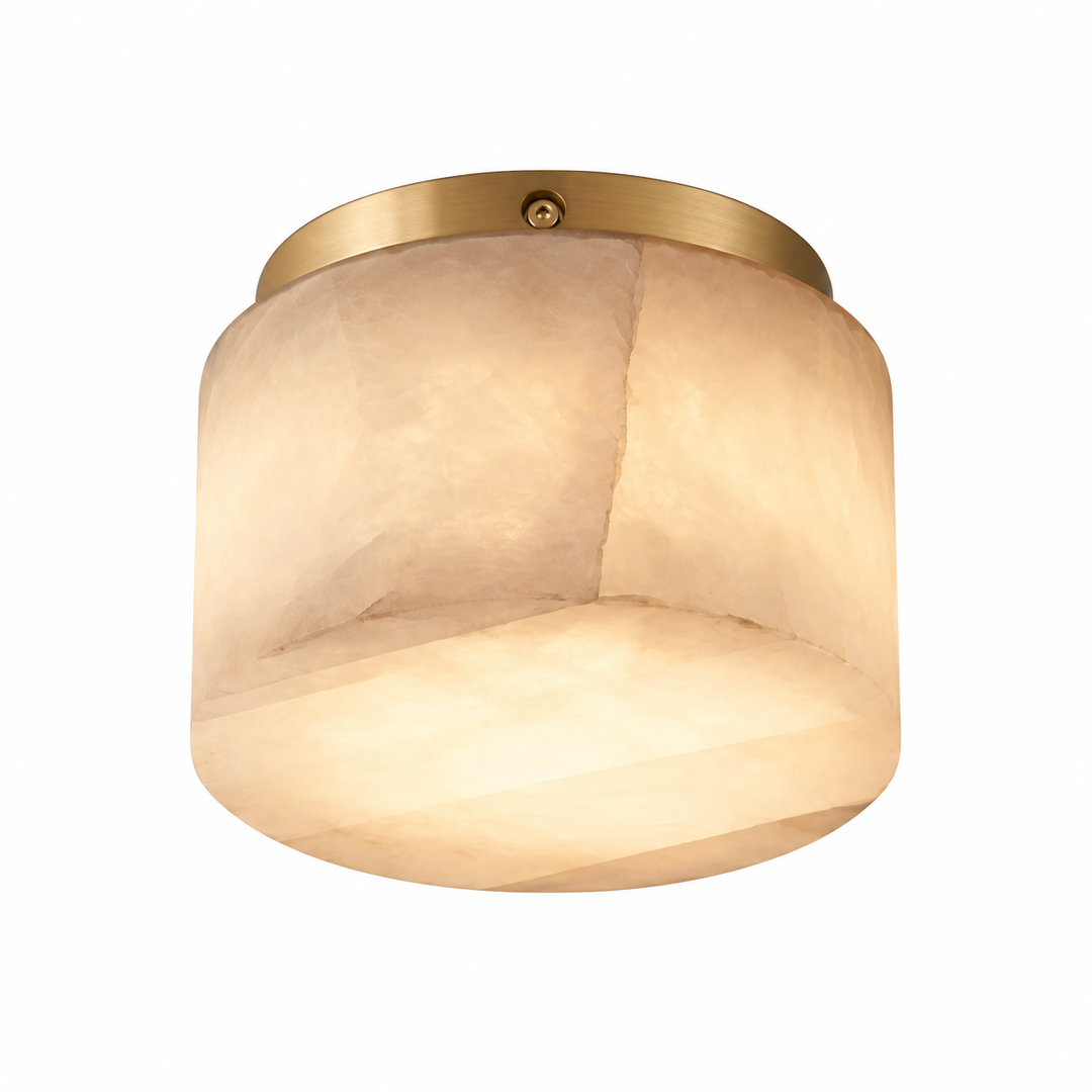 A modern semi-flush mount ceiling light featuring a warm, textured beige glass shade and a brushed brass metal canopy, shown against a solid white background.
