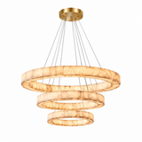 Three-tier alabaster ring chandelier glows warm cream beneath a brushed gold canopy against a white background.