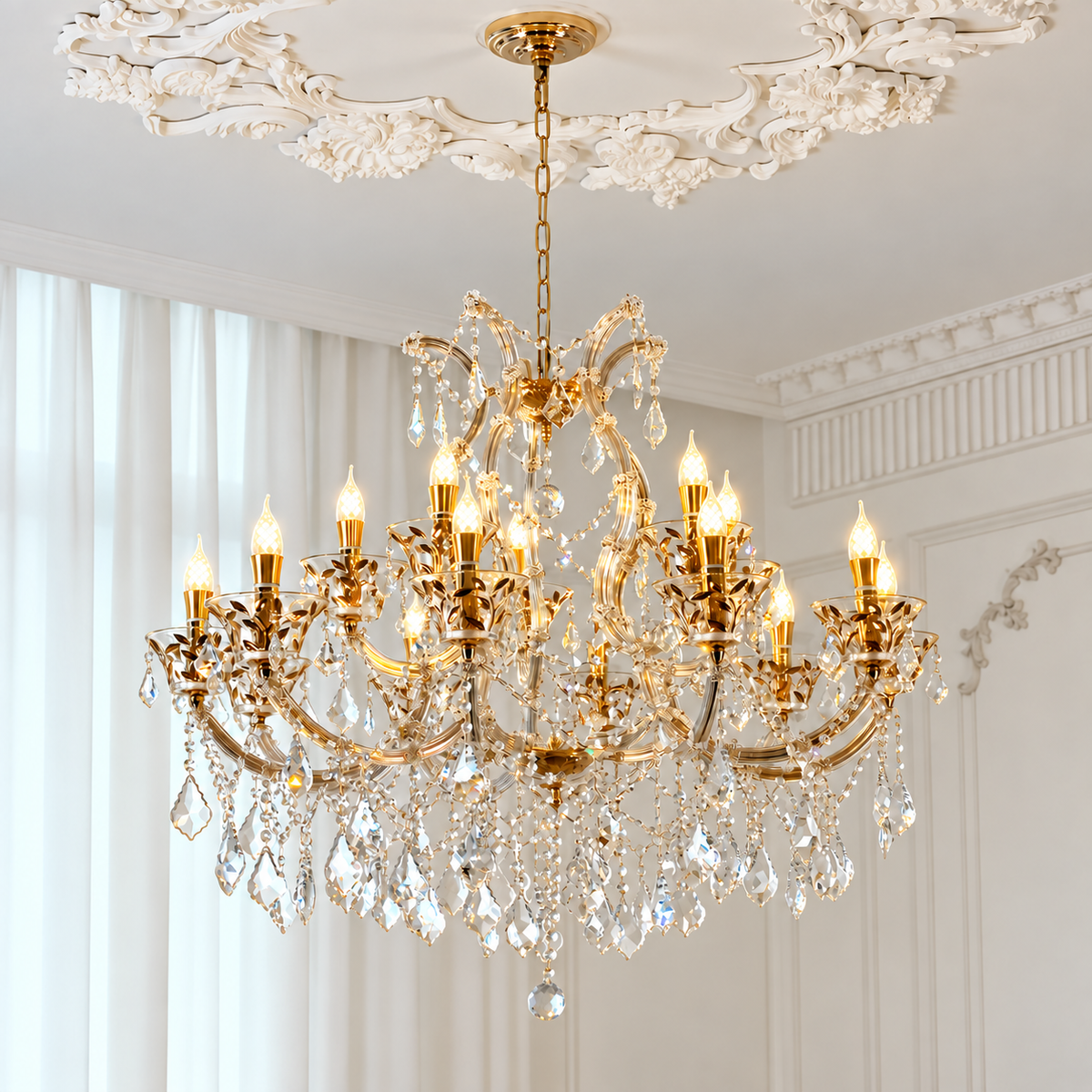 An ornate gold chandelier with multiple candle-style lights and hanging crystal prisms, suspended from a decorative ceiling in a bright, elegant room with white walls and curtains.