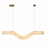 A modern U-shaped linear pendant light made of warm cream-colored stone, suspended by thin cables from two gold square ceiling mounts against a plain white background.
