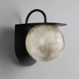 Wall sconce with a cream alabaster globe, black metal frame, and curved loop mounted against a light gray wall.