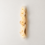 A vertical wall sconce featuring five stacked, irregular natural stone slices that glow warm white when lit, with small gold-toned bulbs set into the center of each stone. The fixture is shown against a clean, off-white background with a soft shadow.
