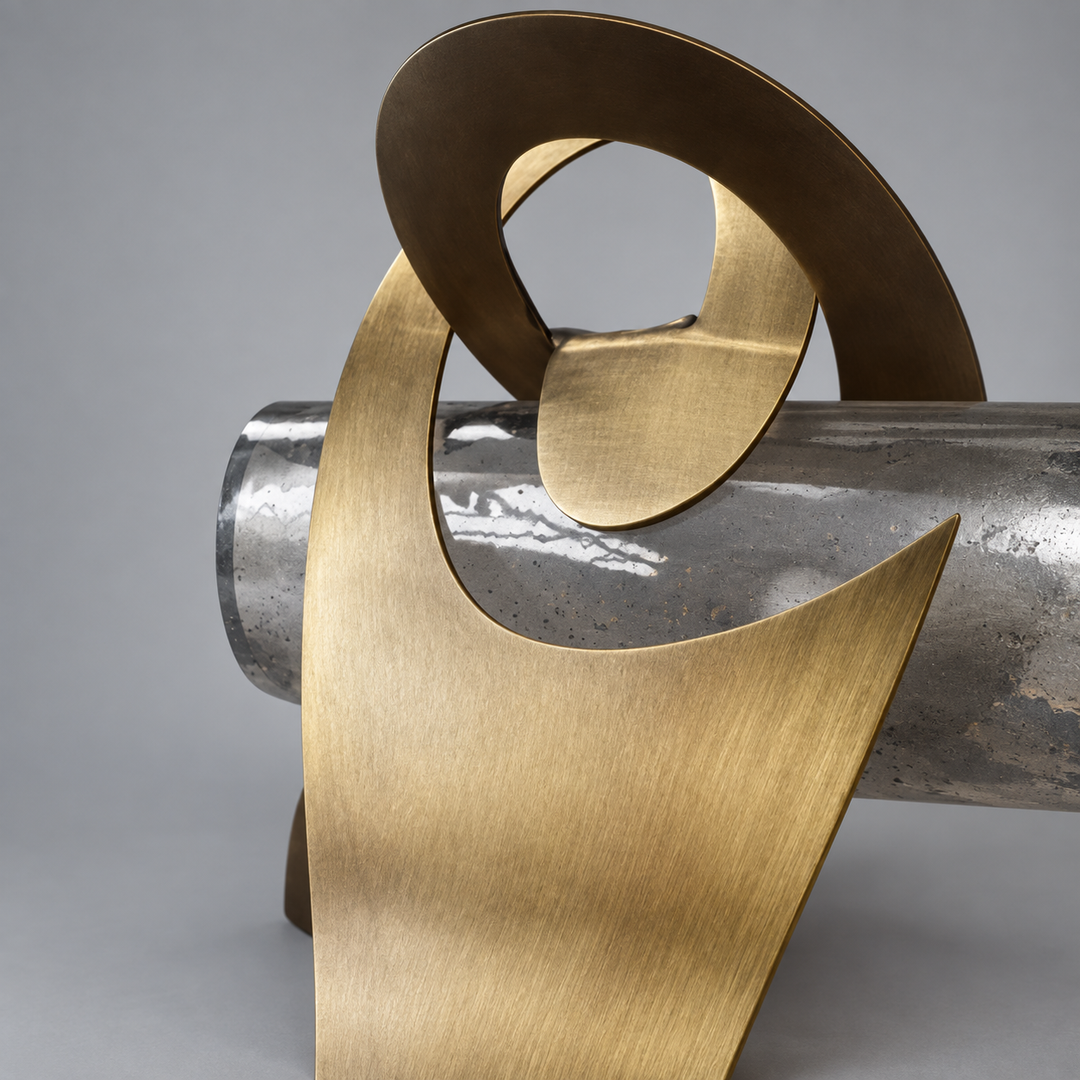 Close-up of a wall sconce with curved antique brass details surrounding a textured glass shade against a gray background.