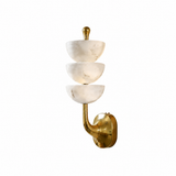 A modern wall sconce featuring three stacked, bowl-shaped white marble shades on a curved brass metal arm with a round wall mount, shown against a plain white background.