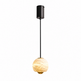 A modern pendant light with a matte black cylindrical ceiling canopy, a slim black cord, and a glowing warm white textured glass globe shade with a gold-toned accent at the bottom.