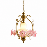 Vintage gold-tone pendant light with pink glass flowers and a frosted white bell shade, hanging on a chain against a plain white background.