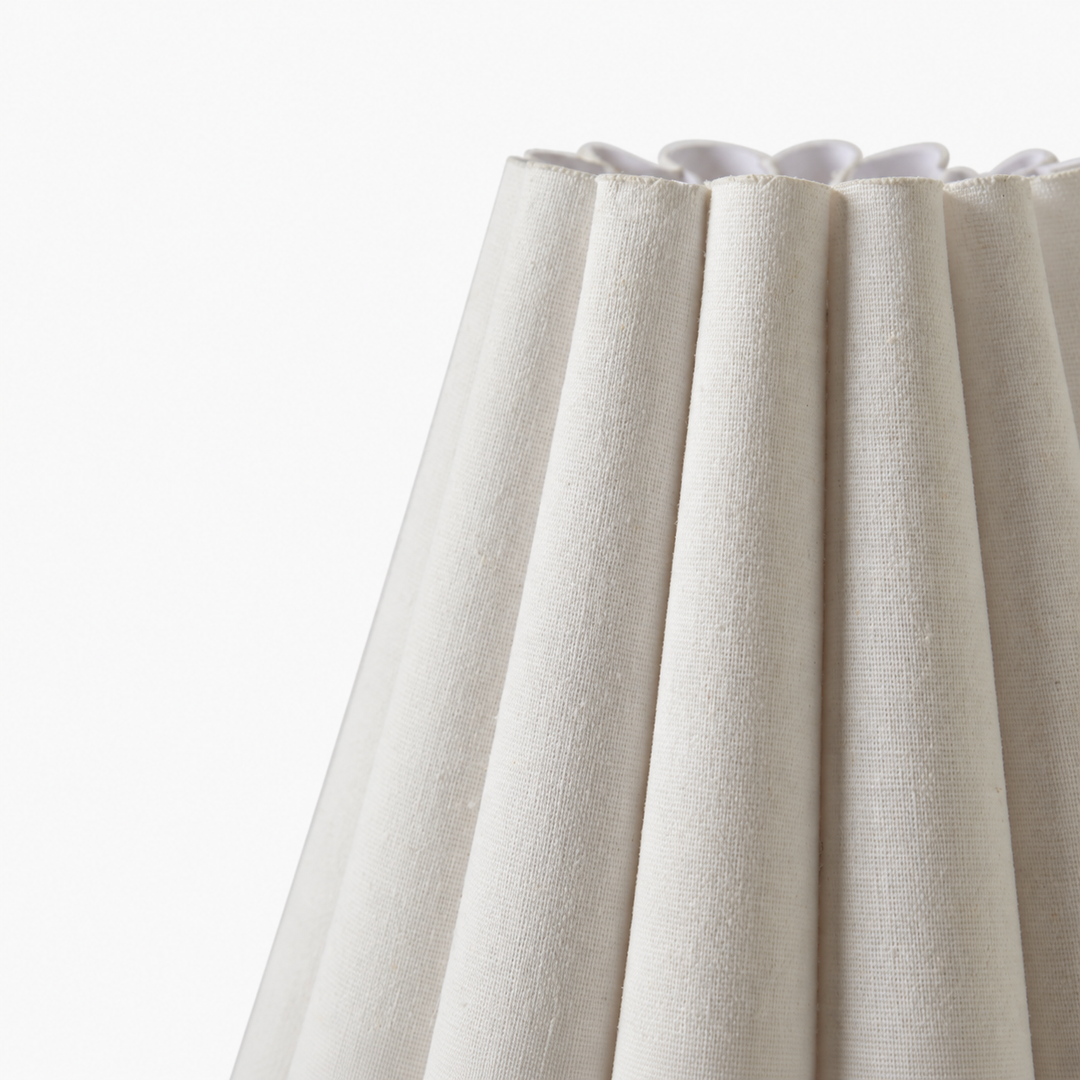 Close-up of the wall sconce’s white pleated fabric shade, showing its woven texture and folded upper edge against a white background.