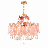 A pink glass chandelier with a gold metal frame, hanging chain, floral accents, and dangling crystal-like beads and teardrop pendants, shown on a plain white background.