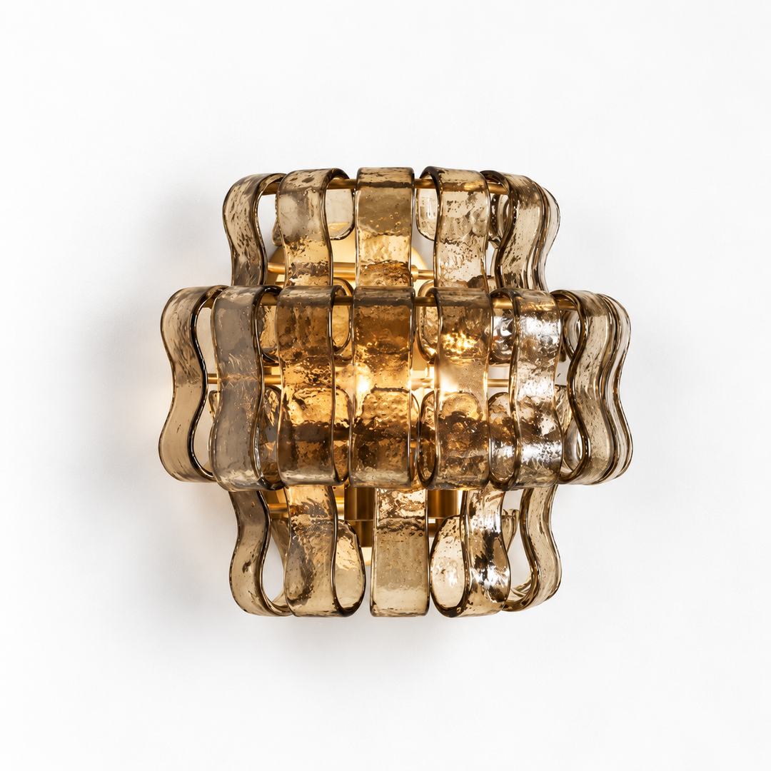 A modern wall sconce light fixture made of wavy, translucent smoky amber glass, shown against a plain white background.