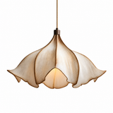A modern pendant light with a sculptural, lotus-like shade made of layered, petal-shaped panels in a warm beige and cream finish, shown illuminated against a solid white background.
