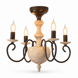 A rustic 5-light chandelier featuring a distressed dark brown metal frame with scrollwork arms, a central turned wood stem, and five candle-style bulbs with warm glowing filaments, set against a plain white background.