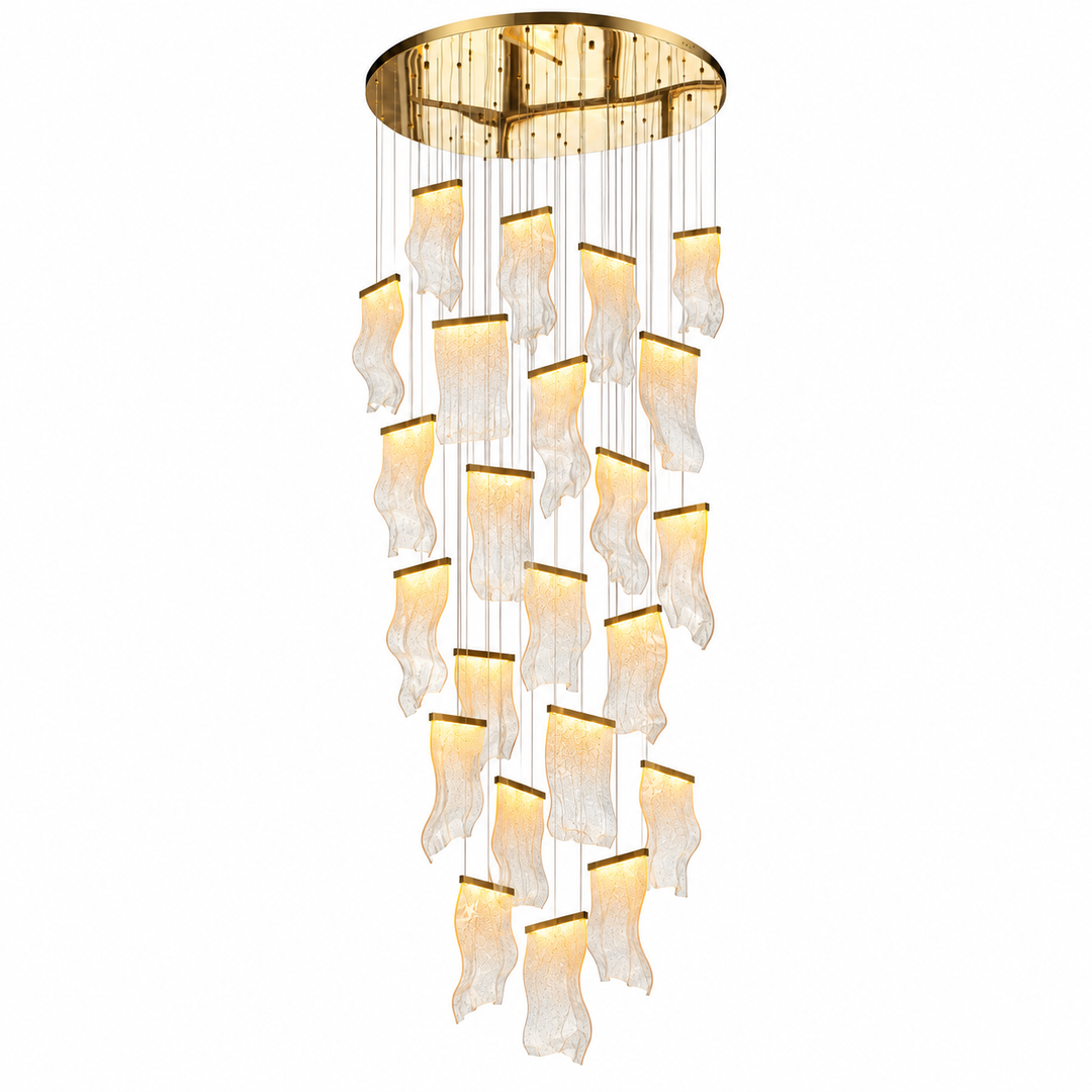 A modern multi-light chandelier with a circular gold ceiling mount, featuring multiple cascading tiers of textured, wavy clear glass shades that glow with warm light, suspended by thin gold wires against a solid white background.