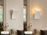 White layered wall sconce beside a mirror and sofa, shown side by side with labels reading Light Off and Light On.