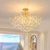 Luxurious crystal chandelier in a room with large windows and a view of trees.