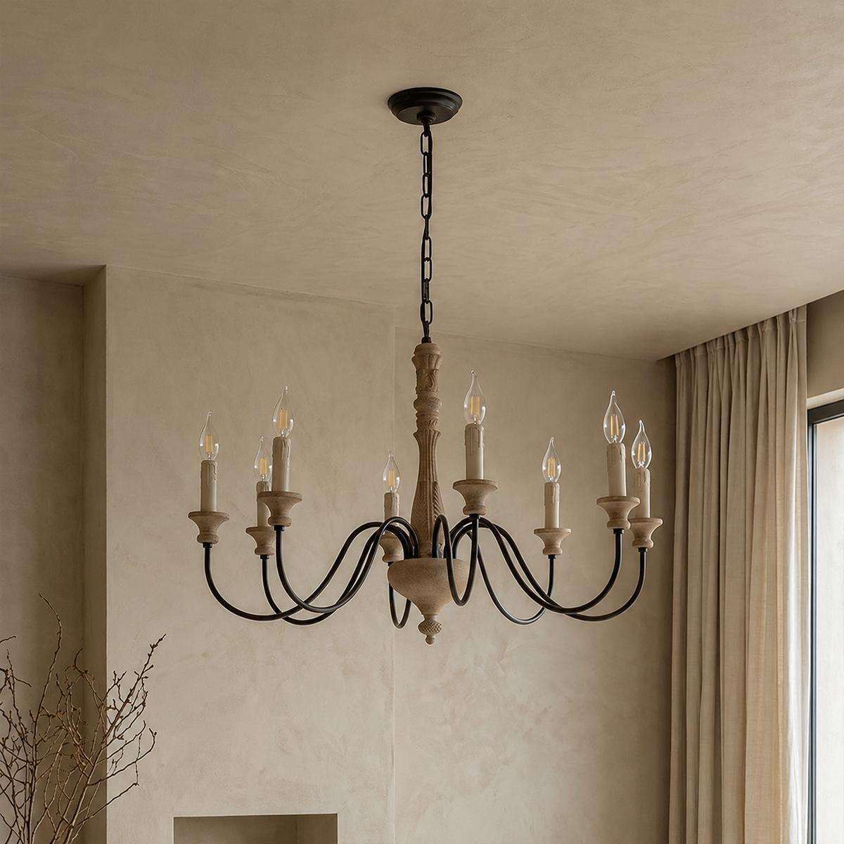 A rustic multi-arm chandelier with a black metal frame and carved beige wood accents, hanging from a chain in a warm, neutral-toned room with textured plaster walls and curtains.