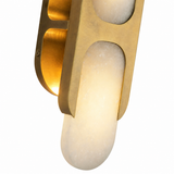 A modern wall sconce light fixture with a brushed brass frame and a frosted white stone or glass cylindrical shade, shown against a plain white background.