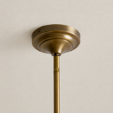 Close-up of the chandelier’s round antique brass-tone ceiling canopy and suspension rod against an off-white ceiling.