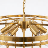 A close-up of a brass multi-light chandelier with a circular frame, six adjustable light sleeves, and clear glass shades, suspended by a chain against a white background.