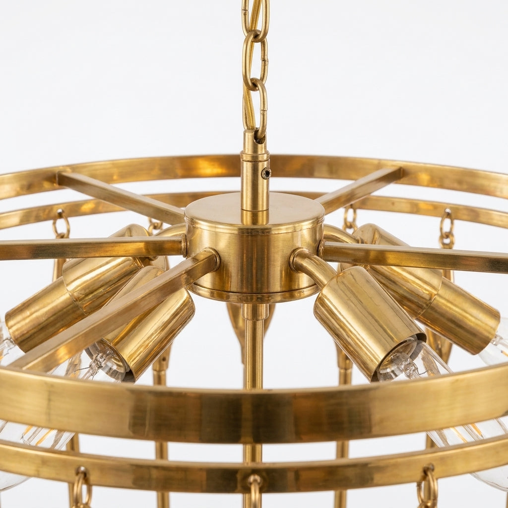 A close-up of a brass multi-light chandelier with a circular frame, six adjustable light sleeves, and clear glass shades, suspended by a chain against a white background.