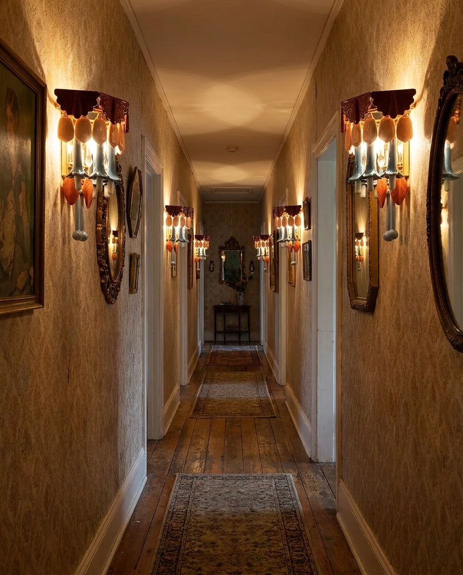 Chandelier-style wall lights with amber and clear glass drops illuminate a narrow hallway with textured walls, mirrors, and wooden flooring.