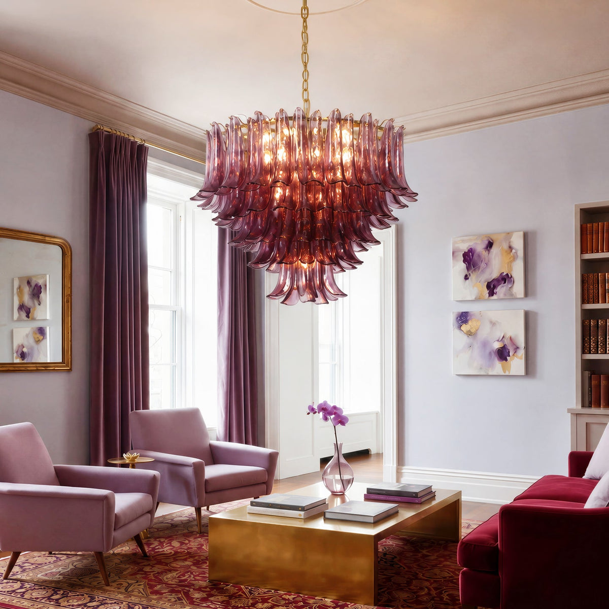 A large tiered chandelier made of translucent burgundy glass, hanging in a styled living room with mauve chairs, a red sofa, and a gold coffee table.