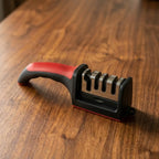 Hand holding the sharpener handle while sharpening a straight-edge kitchen knife