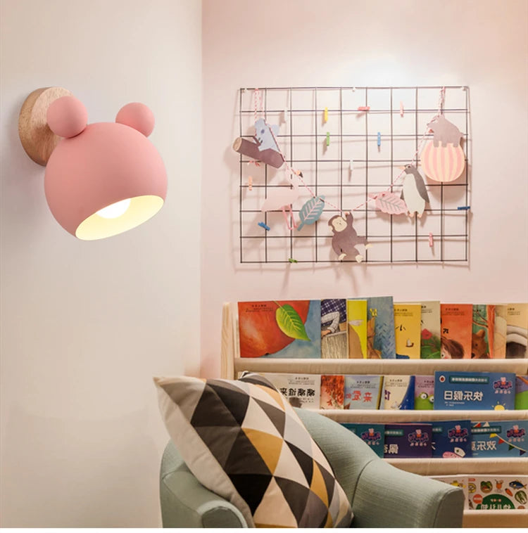 Pink kids wall light in a pink playroom with bookshelf