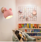 Pink kids wall light in a pink playroom with bookshelf