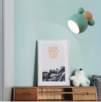 Green bear wall light on a mint wall above a kids bookshelf