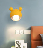Yellow wall lamp lit on a blue wall above an orange headboard