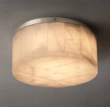 Illuminated alabaster drum flush mount light with cream veining and a silver-colored rim against a gray ceiling.