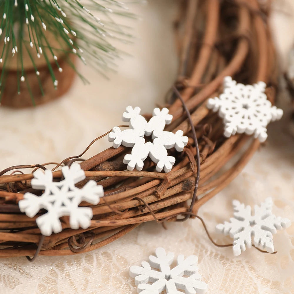 White wood snowflake ornaments in different patterns rest on a brown twig wreath and cream lace beneath green foliage.