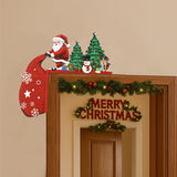 Wooden door corner decoration with Santa, green trees, a snowman, reindeer and a hanging red sack sits on a wooden mirror frame.